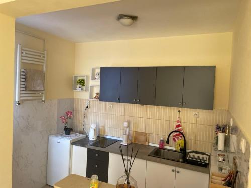 a kitchen with black cabinets and a white refrigerator at SkyBreak Apartment in Ledine