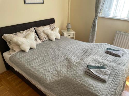 a bed with towels and pillows on top of it at SkyBreak Apartment in Ledine
