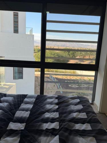 a bedroom with a bed and a large window at Ayla golf in Aqaba