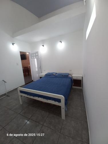 a bedroom with a blue bed in a white room at La Leonor in Formosa