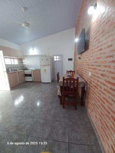 a room with a table and a brick wall at La Leonor in Formosa