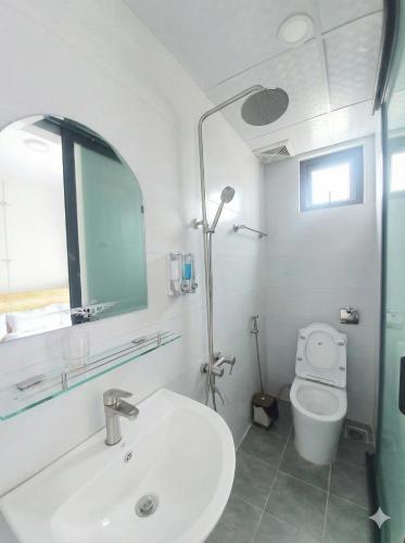 a white bathroom with a sink and a toilet at Hello Dalat Hostel in Da Lat