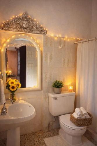 a bathroom with a toilet and a sink and a mirror at La Casita Inn Bustamante in Bustamante