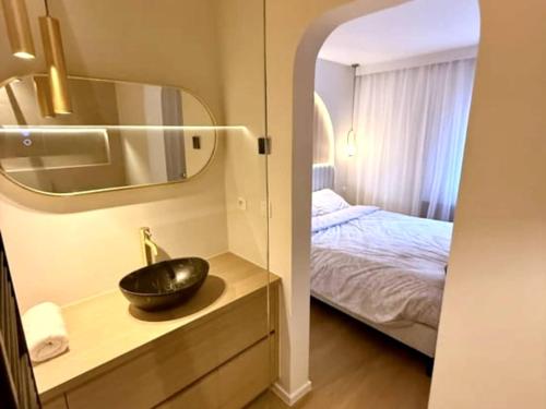 a bathroom with a sink and a bed in a room at Luxury apartment with sea view in Westende-Bad