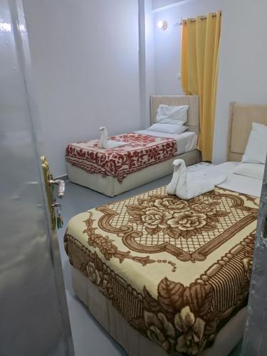 a couple of beds sitting in a room at Bob marley luxor in Luxor