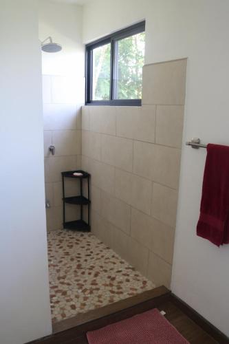 a bathroom with a shower with a window at Villa Nomad in Naranjito