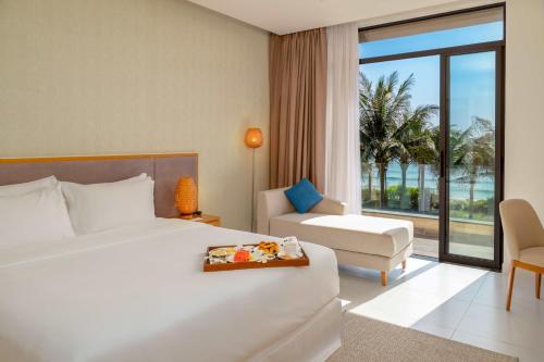 a hotel room with a bed and a chair at Lumina Villas Cam Ranh, Bai Dai beach luxury resort villas in Cam Ranh