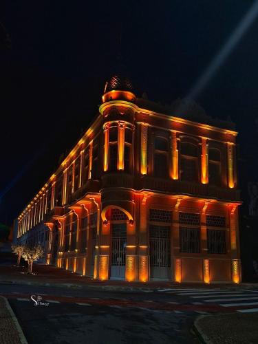 a building lit up in orange lights at night at Hotel Central in Amparo