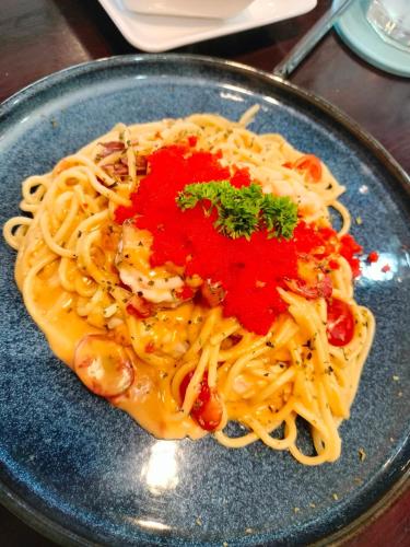 a plate of pasta with sauce and parsley on it at แอนนา เรสซิเดนซ์ in Ban Dung