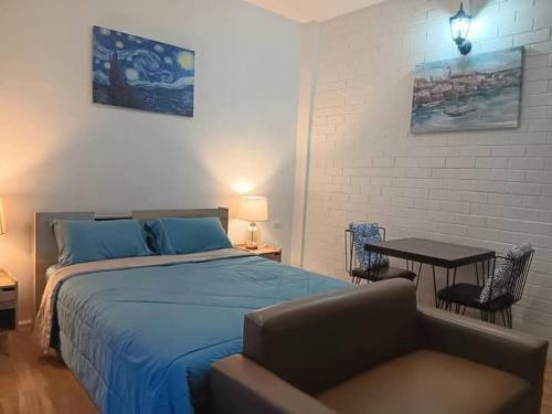 a bedroom with a bed and a table and chairs at แอนนา เรสซิเดนซ์ in Ban Dung