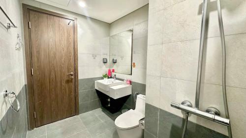 a bathroom with a toilet and a sink and a mirror at 2 Giường view Bể bơi Family Room with Pool view in Long Bình