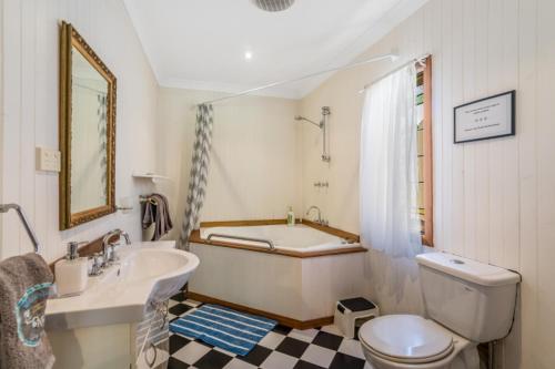 a bathroom with a tub and a toilet and a sink at Firefly Resort in Firefly