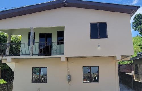 ein weißes Haus mit Balkon und Fenstern in der Unterkunft Tranquil Escape in Arima