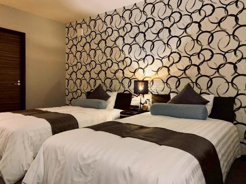 two beds in a hotel room with a wall mural at scène セヌ in Daisen