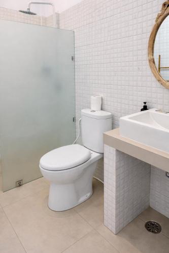 a white bathroom with a toilet and a sink at Bali intan Canggu in Canggu