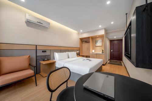 a hotel room with a bed and a table and a tv at Kaboting Hotel Chongqing Prime Location Near Jiefangbei & Hongya Cave, 1 Minute Walk to Metro, Ideal for International Guests,Free Self-Service Laundry, Free High-Speed WiFi,Free Chinese Tea, Free Travel Advice in Chongqing