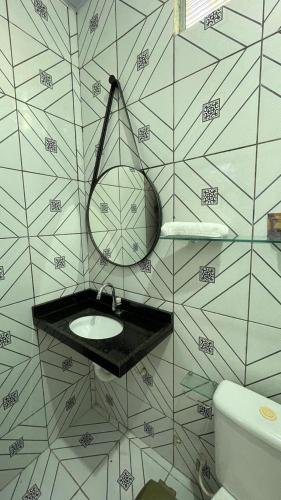 a bathroom with a sink and a mirror on a wall at Chalé Marinas in Barreirinhas