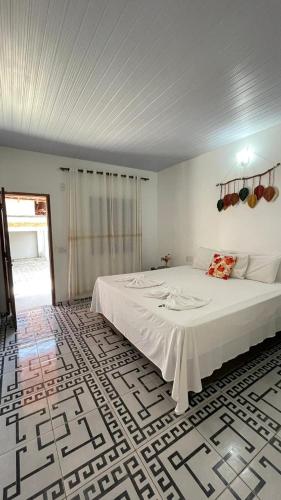 a bedroom with a large white bed in a room at Chalé Marinas in Barreirinhas