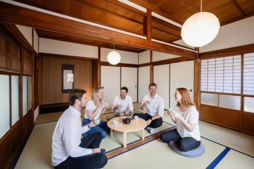 a group of people sitting around a table in a room at Kizuna House Yuzuriha in Minamiawaji