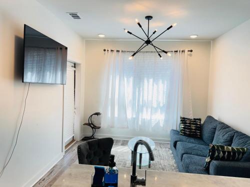 a living room with a blue couch and a tv at Downtown Atlanta Home Away From Home in Atlanta