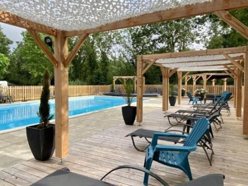 a wooden deck with chairs and a swimming pool at Chalet avec animaux acceptés - 2 pers. - API-1-52-2308 in Coulon