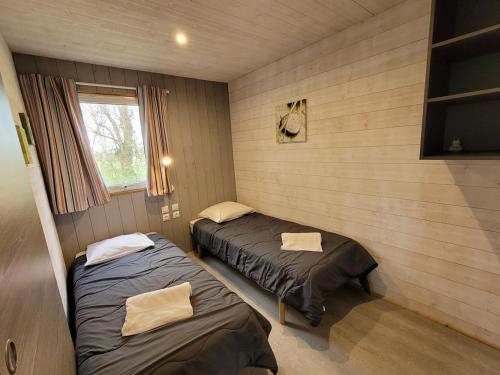 two twin beds in a room with a window at Chalet clim - 4 pers. - API-1-52-2324 in Coulon