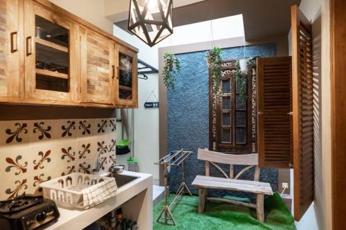 a kitchen with a green rug and a chair at Sabi House Lesmana in Timuran
