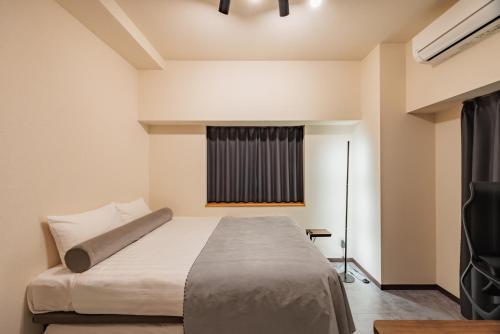 a bedroom with a bed and a window at Work Friendly Room 3 min to Station Simmons Bed WiFi and Desk in Nagoya
