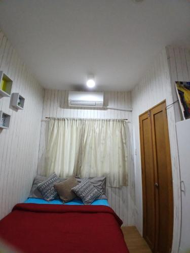 a small room with a bed with a window at Sol house in Pajak