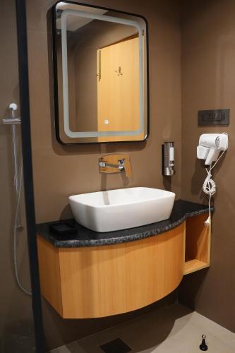 a bathroom with a sink and a large mirror at Jeeva Premium Rooms in Dalhousie
