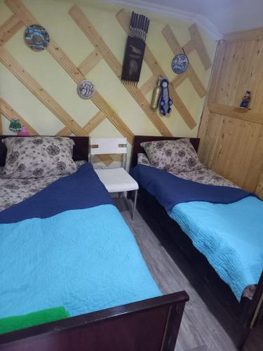 two beds in a room with wooden ceilings at Mera Hostel in P'arts'khanaqanevi