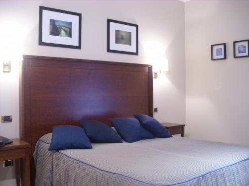 a bedroom with a bed with blue pillows on it at Hotel Taormina in Rome