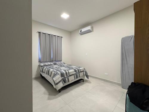 a bedroom with a bed in a room with a window at New House, Long Stay in Maringá