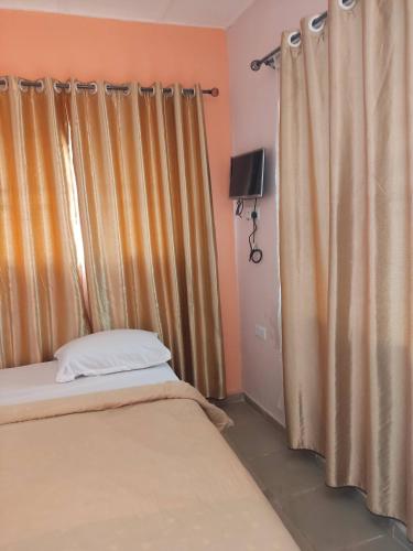 a bedroom with two beds and a window with curtains at Geobajas Hotels in Imushin