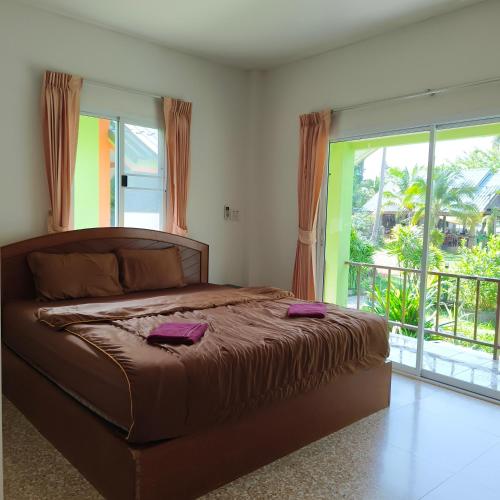 ein Schlafzimmer mit einem großen Bett und einem Balkon in der Unterkunft The Rusty Plank in Ban Dan Kao