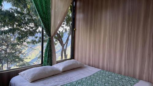 a bed in a room with a large window at Sơn Tra Our House in Bản Bé