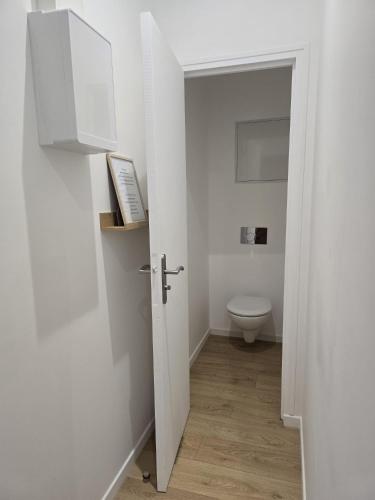 a bathroom with a toilet and a white door at La Tour d'Harfleur 2 in Caudebec-en-Caux