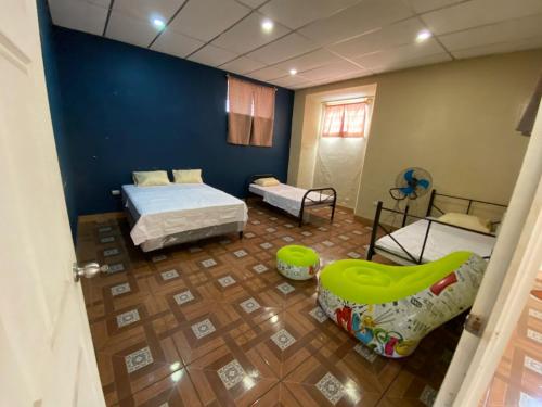a room with two beds and a chair in it at Hostal Casa Colonial in Santa Ana