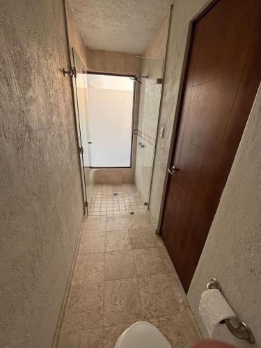 a bathroom hallway with a toilet and a door at Loft familiar campestre en Atlixco in Atlixco