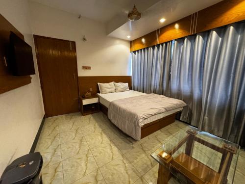 a small bedroom with a bed and a television at Hotel Seven View in Bāiljuri
