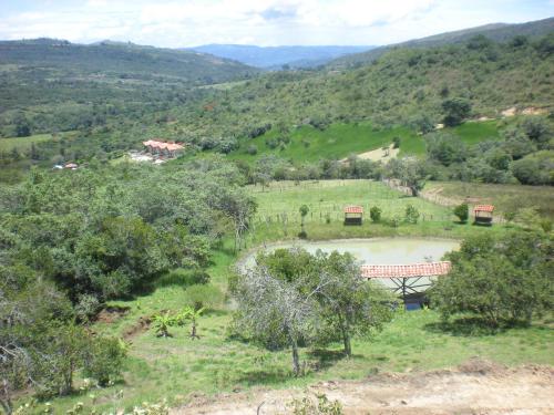 a view of a valley with a bridge and a pond at Hotel La Montoya in Curití