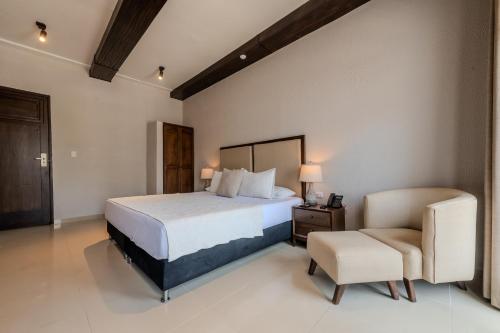 a bedroom with a bed and a chair at Hotel Dorado Plaza Centro Histórico in Cartagena de Indias
