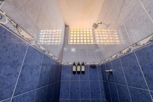 a bathroom with a blue tiled shower with windows at Hotel Dorado Plaza Centro Histórico in Cartagena de Indias