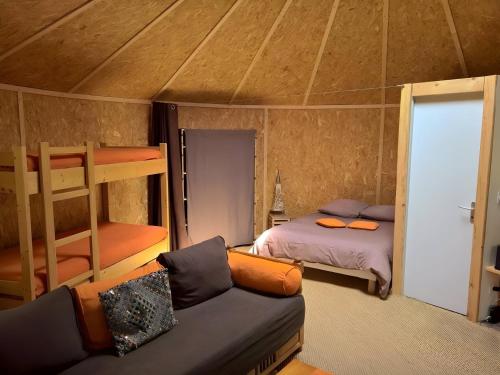 a bedroom with a bunk bed and a couch at Gite 4 etoiles en pleine nature 8 pers. in Entrepierres