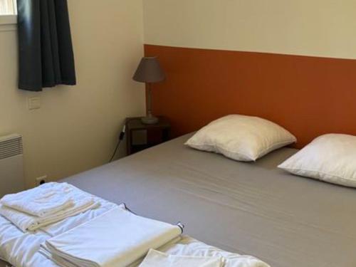 a bedroom with a bed with two pillows on it at Appartement confortable - 4 pers. - API-1-52-2527 in Saint-Hilaire-de-Riez