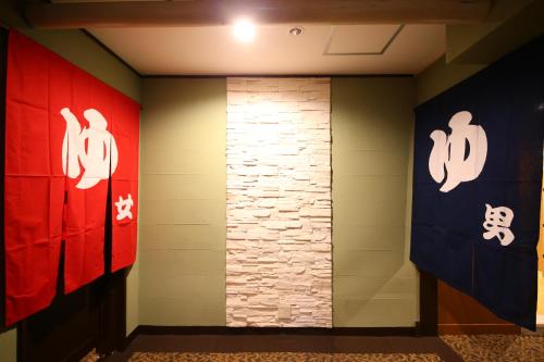 a hallway with chinese paintings on the walls at Hotel Japan Shiga in Yamanouchi