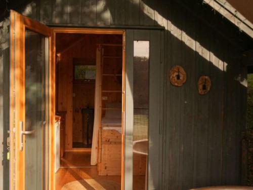 a house with a door open to a room at Cabane cosy pour 2 avec jacuzzi - API-1-52-2485 in Saint-Amand-de-Coly