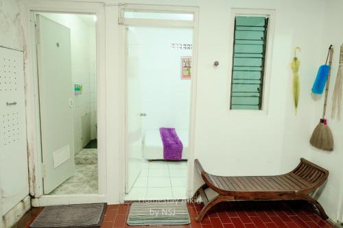 a bathroom with a bench and a shower at Homestay Alkid in Timuran