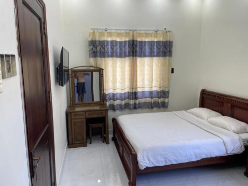 a bedroom with a bed and a mirror and a dresser at Beachside home in Phú Quốc