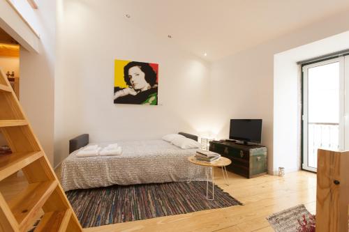 a white bedroom with a bed and a television at Alfama Fado Loft in Lisbon